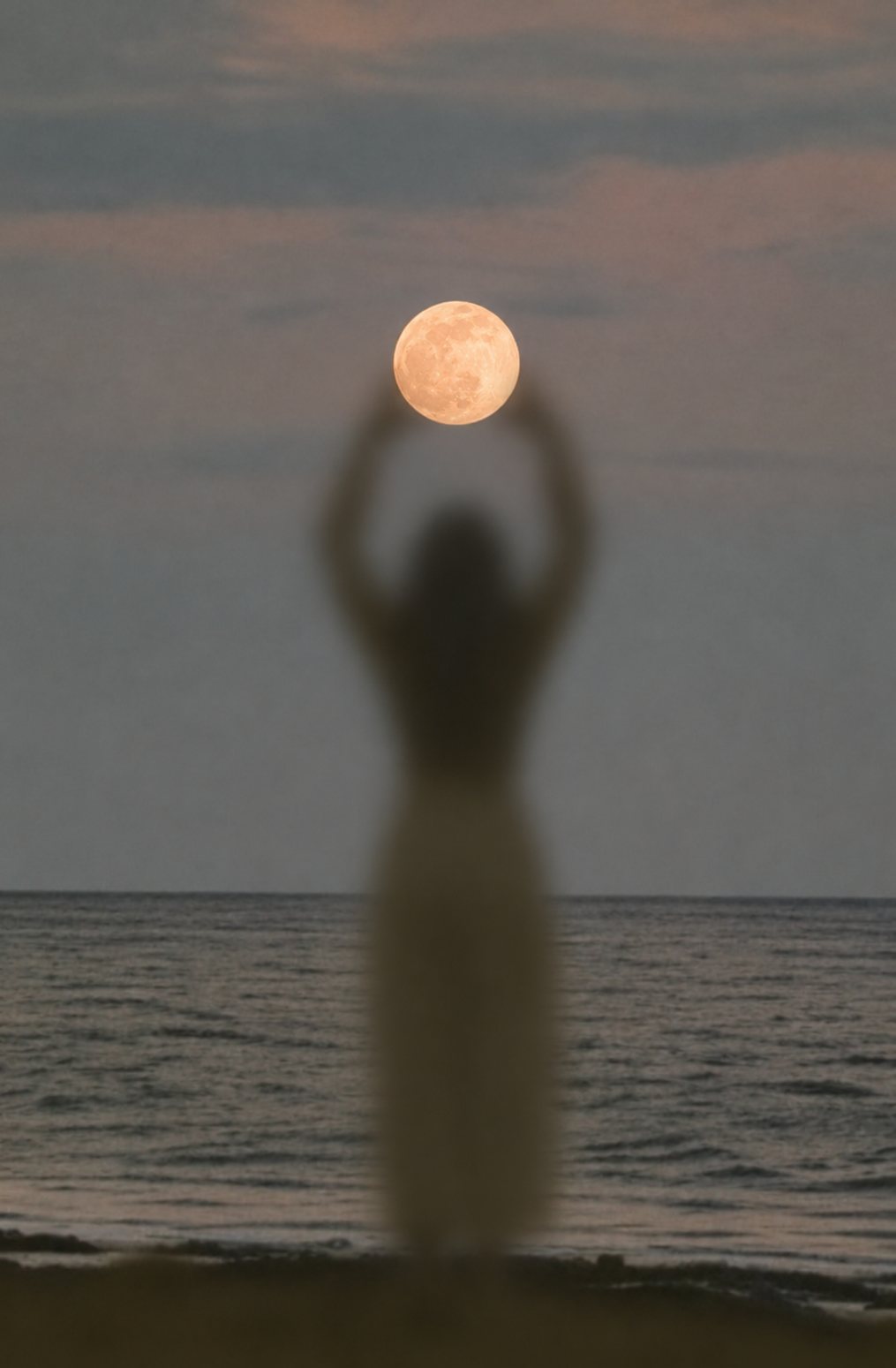 Silueta de una mujer junto al mar sosteniendo la luna llena